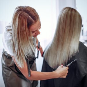 Hairdresser cut hair her client. Woman in a hair salon