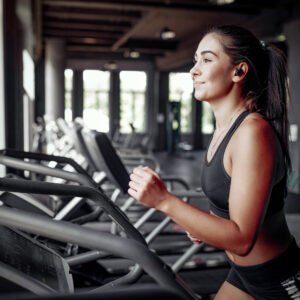 Girl in a gym. Woman on a racetrack. Lady in a black top.