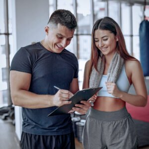 Handsome man in a gym. Sportspeople in a sportswear. Woman training with coach